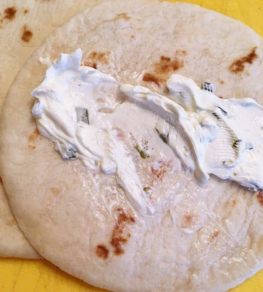 Spreading cream cheese on Tortillas