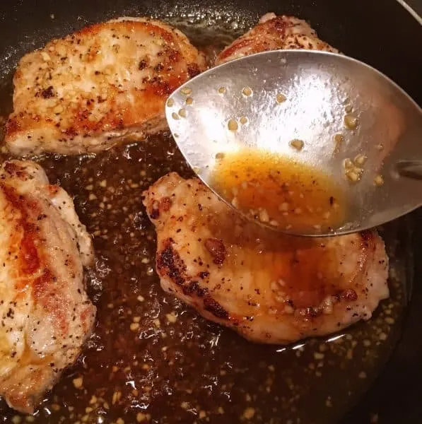 Spooning glaze over pork chops