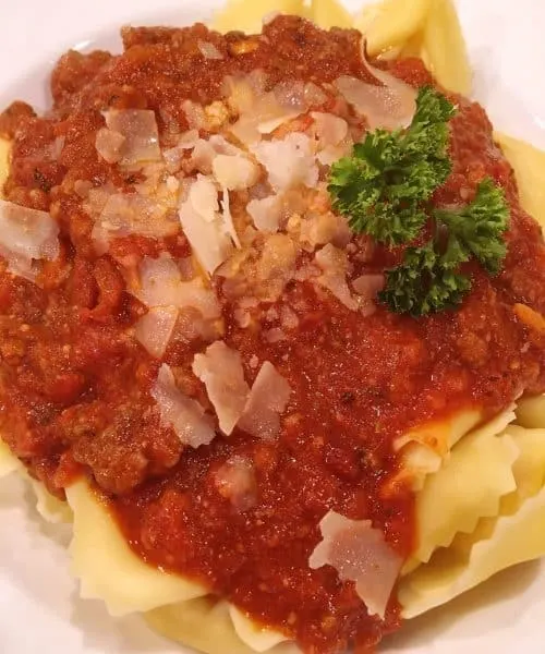 plate full of tortellni sun dried meat sauce