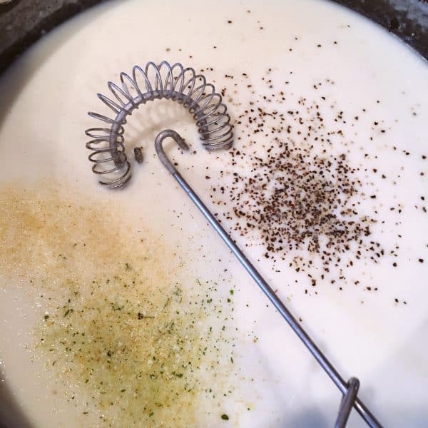 Cream sauce with seasonings being added