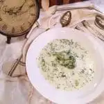 Cream of Broccoli Soup in a white bowl with a spoon.