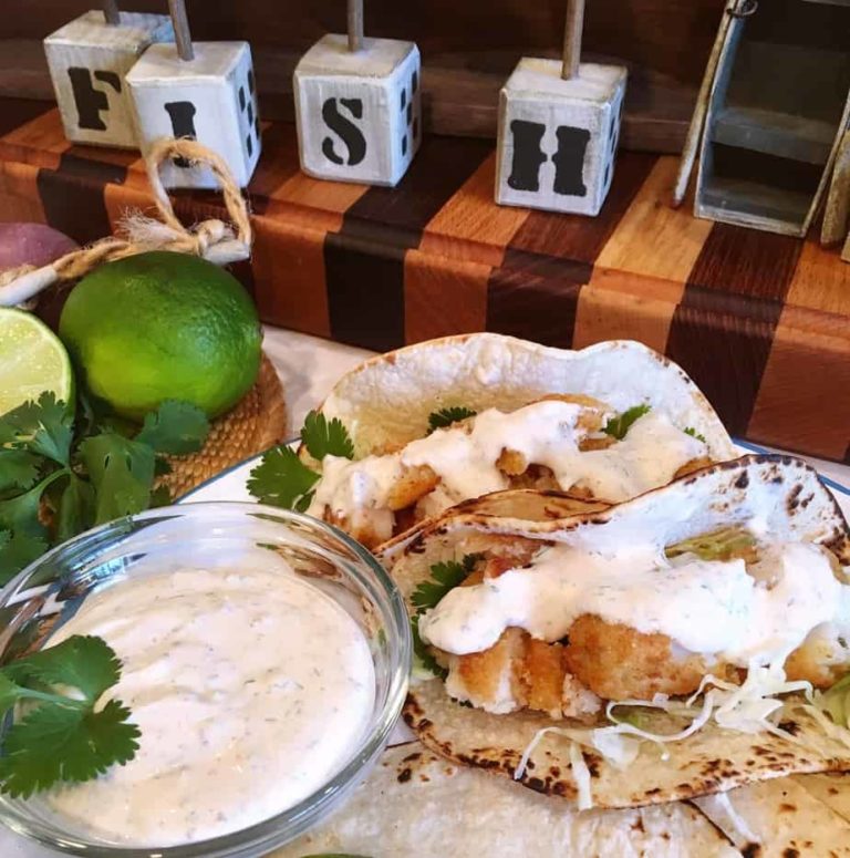 Easy Fish Tacos with Amazing Taco Sauce on a cutting board.