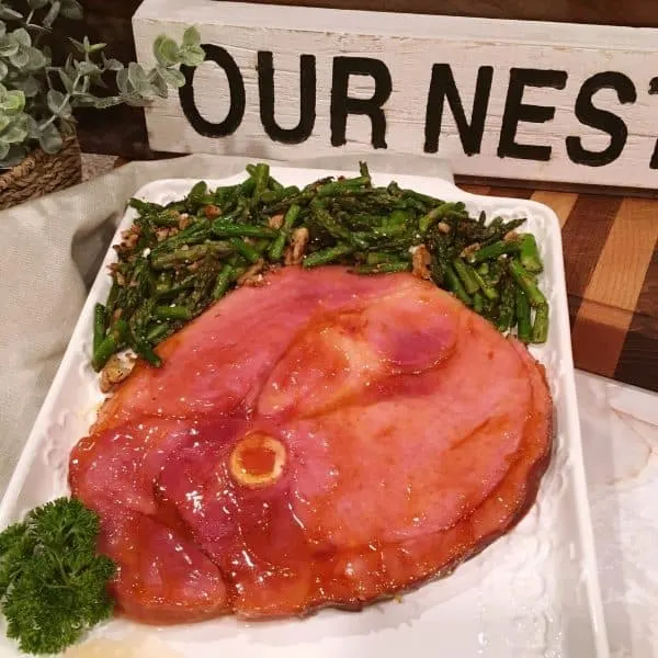 plated ham steak with a side of asparagus