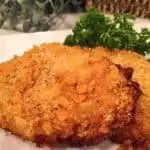 Two Oven Fried Butter Crumb Pork Chops on a white plate ready to eat!