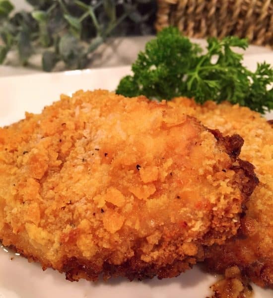 Two Oven Fried Butter Crumb Pork Chops on a white plate ready to eat!