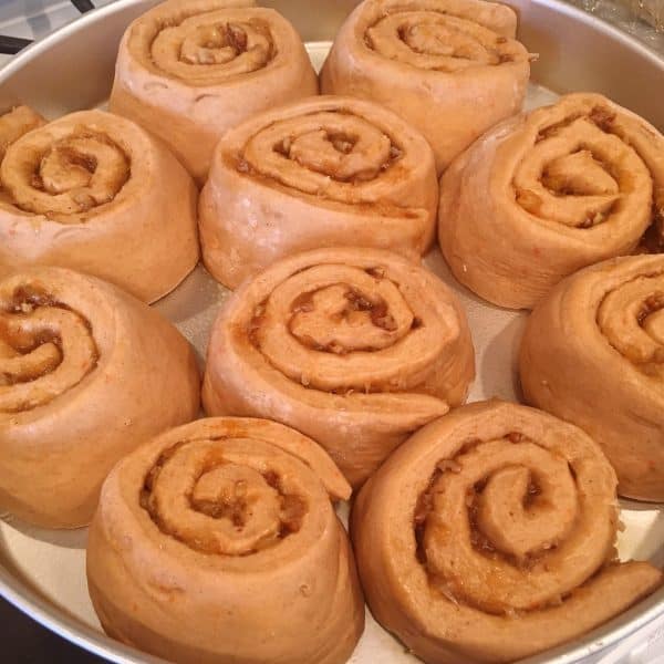 Carrot cake cinnamon rolls raised in pan until double in size.