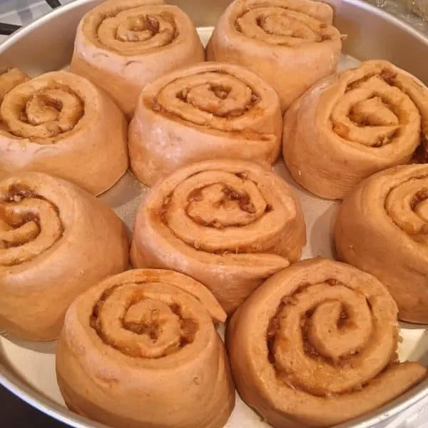Carrot cake cinnamon rolls raised in pan until double in size.