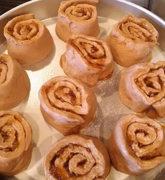 carrot cake mix cinnamon roll dough cut into 2 inch slices and placed in a prepared pan.