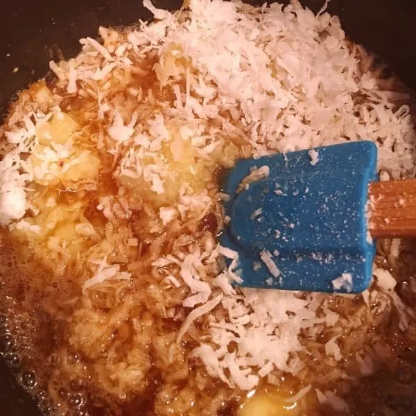 Adding crushed pineapple and shredded coconut to brown sugar and butter for filling.