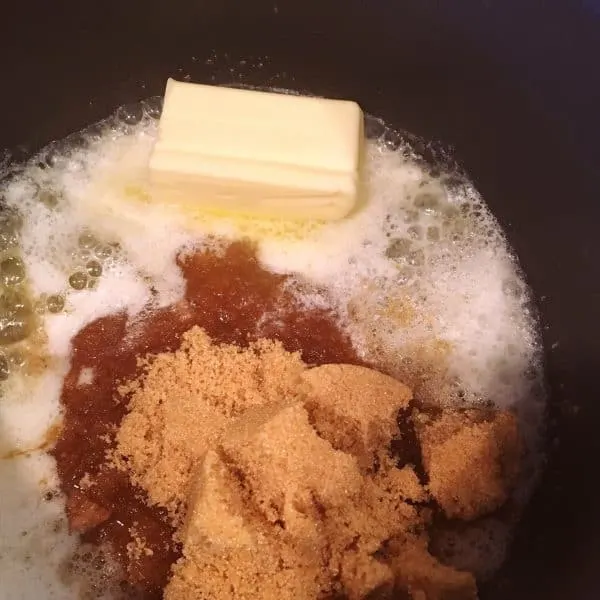 Brown sugar being added to melted butter in sauce pan.