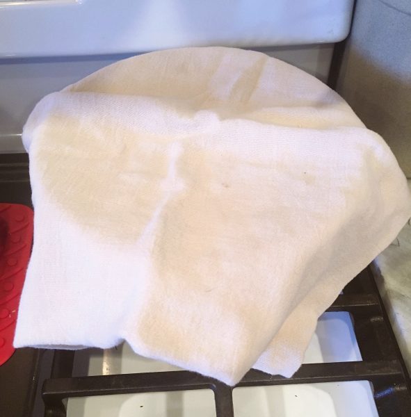Dough bowl covered with cloth and placed on warm stove to allow dough to rise.
