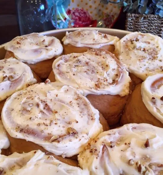 Full pan of baked carrot cake mix cinnamon rolls with frosting