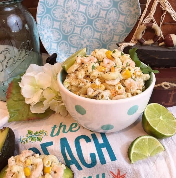 Mexican Seafood Pasta Salad on a beach towel with sliced limes.