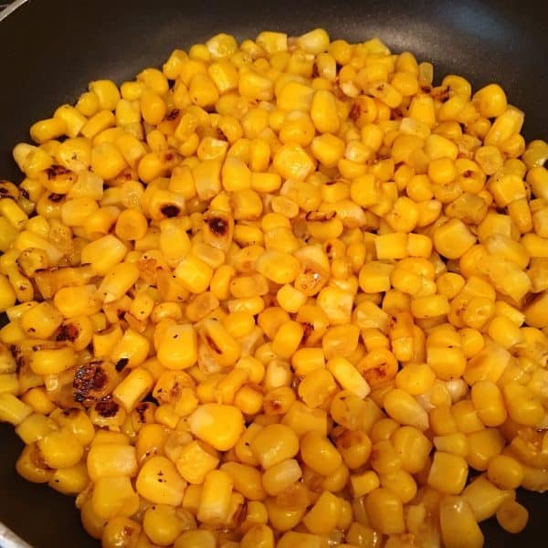 Roasted canned corn in butter in a hot skillet on stove.