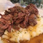 Mississippi Pot Roast and gravy on a bed of garlic cheddar mashed potatoes