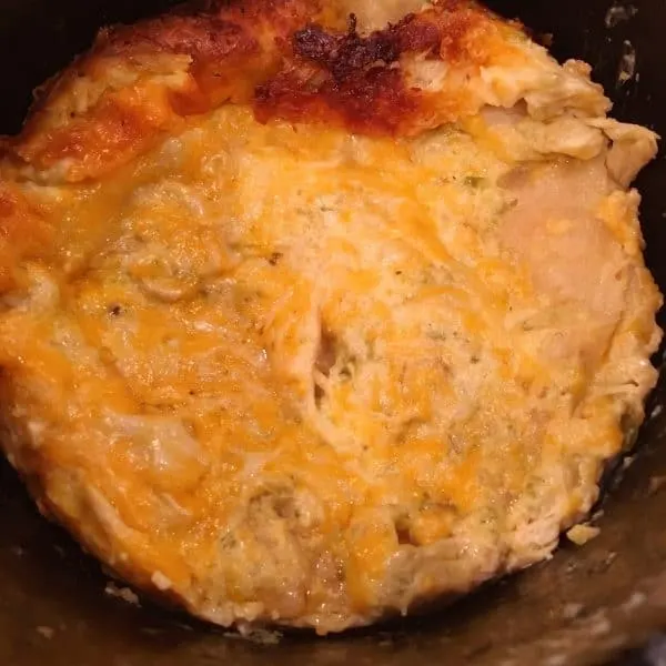 Golden melted cheese on top of baked slow cooker layered chicken enchilada casserole. Crispy golden top.