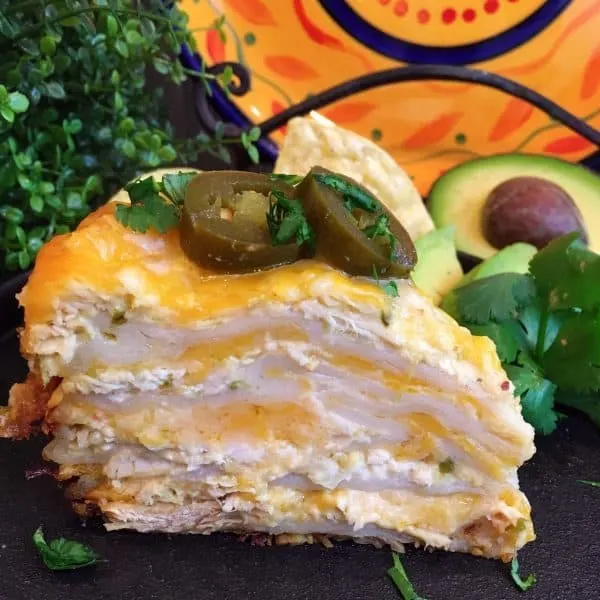 Slice of Layered Slow Cooker Chicken Enchilada Casserole. Topped off with sliced jalapeno's.