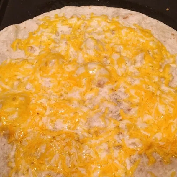 Melted cheese on flour tortilla on grill