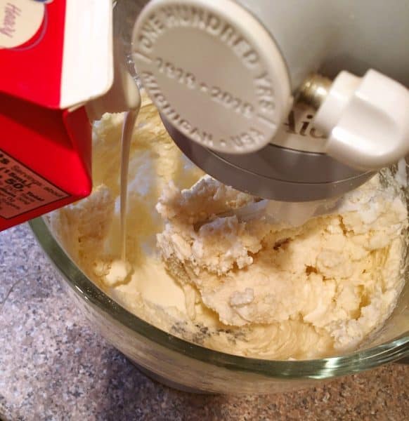 Adding heavy whipping cream to frosting mixture