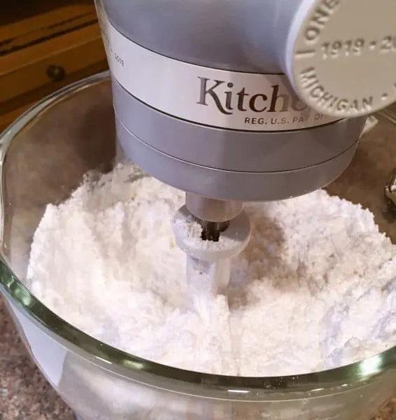 Adding powder sugar to creamed butter in mixing bowl