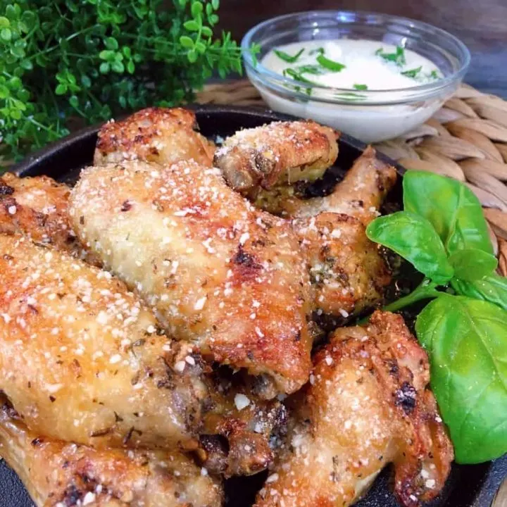 Air Fryer Parmesan Wings on a iron skillet with dipping sauce