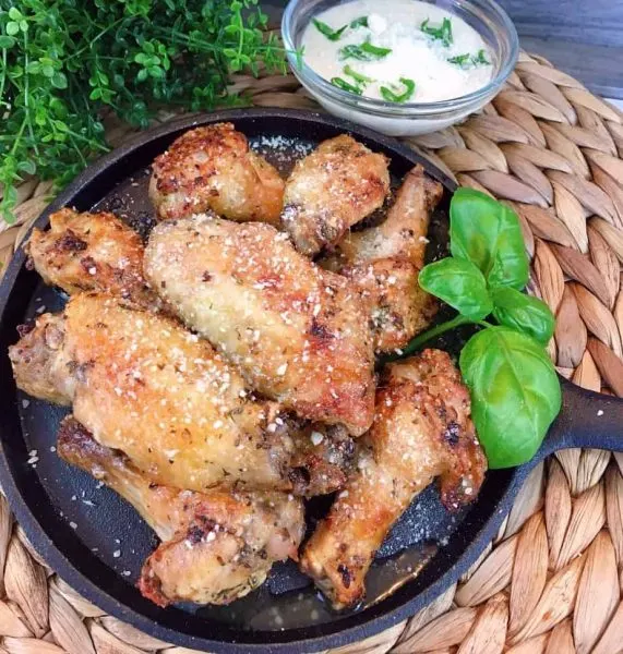 Air Fryer Garlic Parmesan Wings on Cast Iron skillet with dipping sauce.