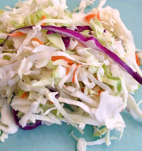 3 Cups of cabbage mix on a cutting board for green apple slaw