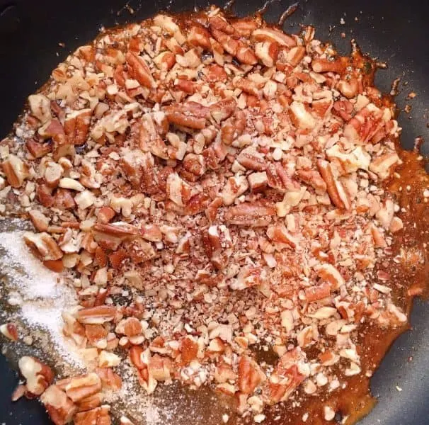 Adding chopped pecans to the caramelized sugar.