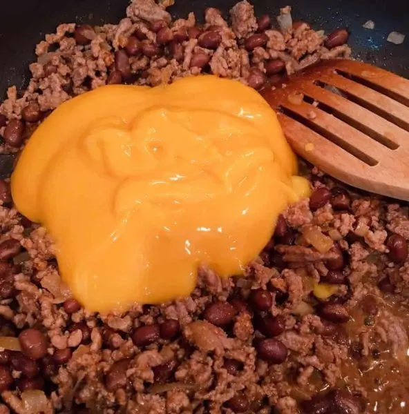 Adding 1 can cheddar soup to hamburger mixture