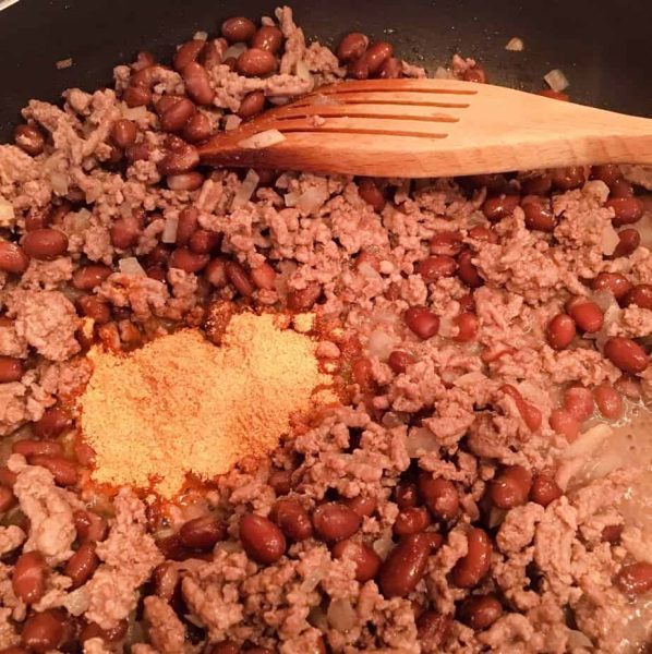 ground beef with beans and taco seasoning in skillet.