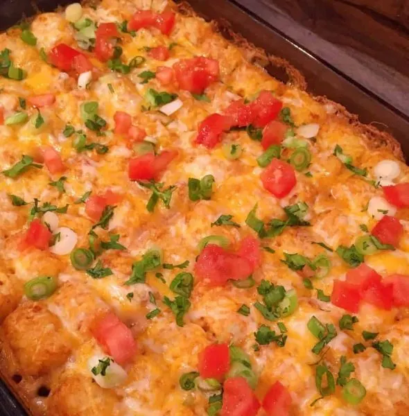 Casserole topped with chopped cilantro, green onions, and tomatoes