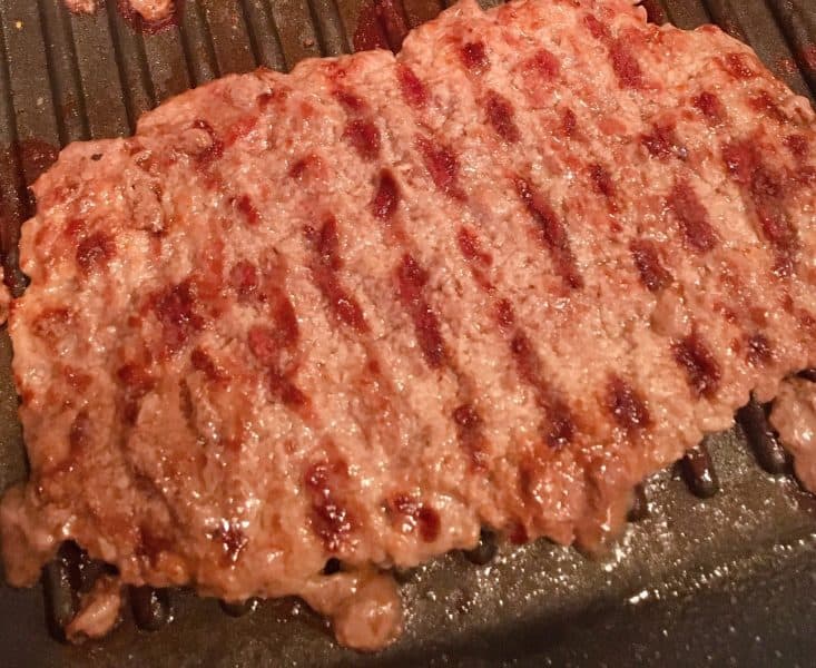 Grilled Hamburger Patty in grill pan on top of the stove.