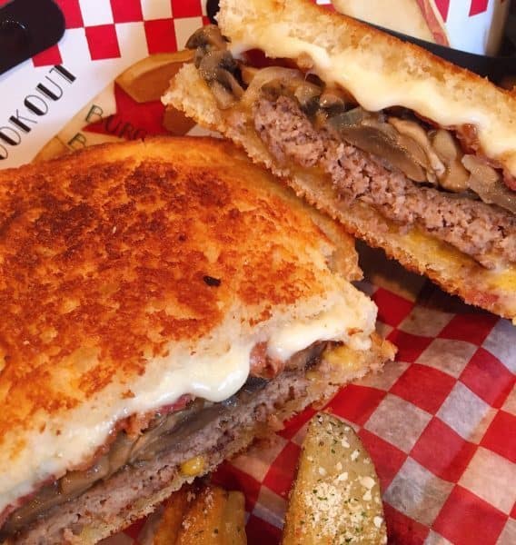 Ultimate Bacon Cheese Patty Melt on a checked paper ready to eat!