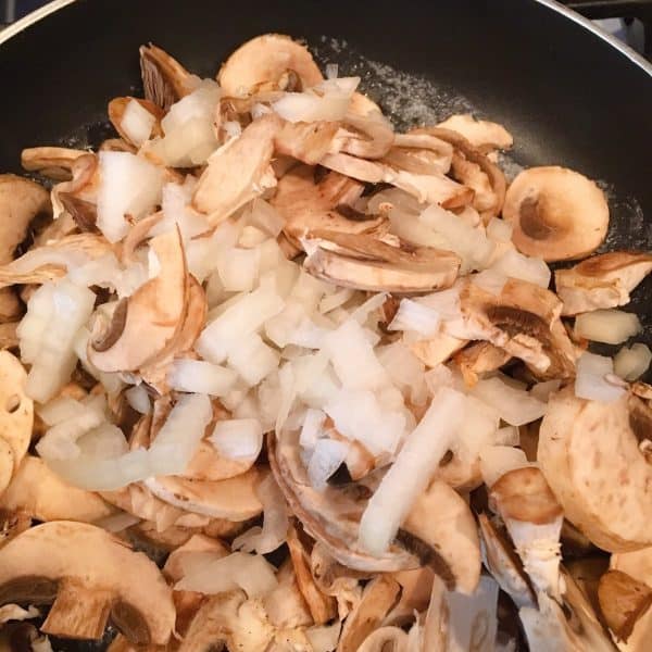Mushrooms and onions in a hot skillet.