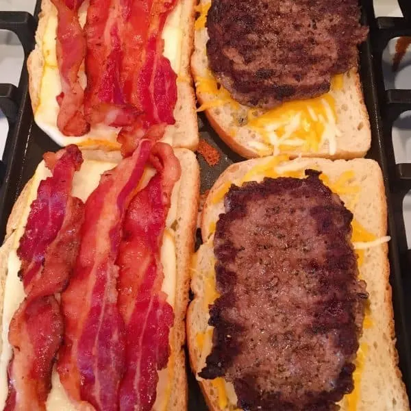 Bread and cheese on grill added hamburger patties and bacon.