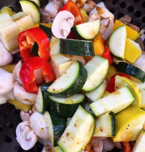 Vegetables with grilled meats in grilling basket on hot BBQ