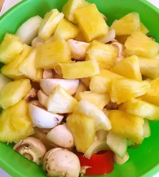 Mushrooms and pineapples cut up in bowl