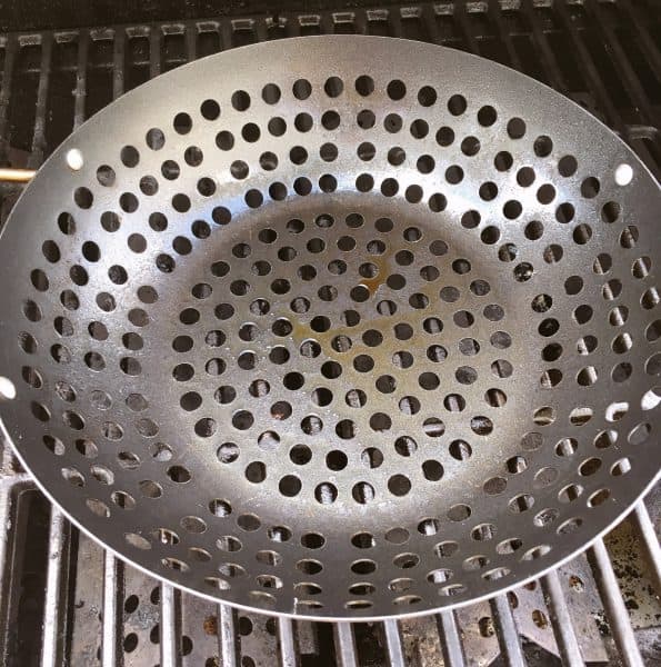 Grilling basket on hot grill sprayed and ready to grill