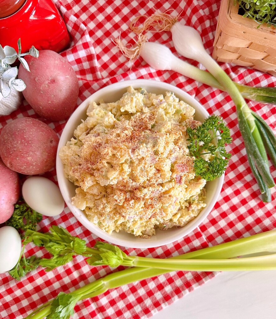 Overhead photo of potato salad with ingredients surrounding it.