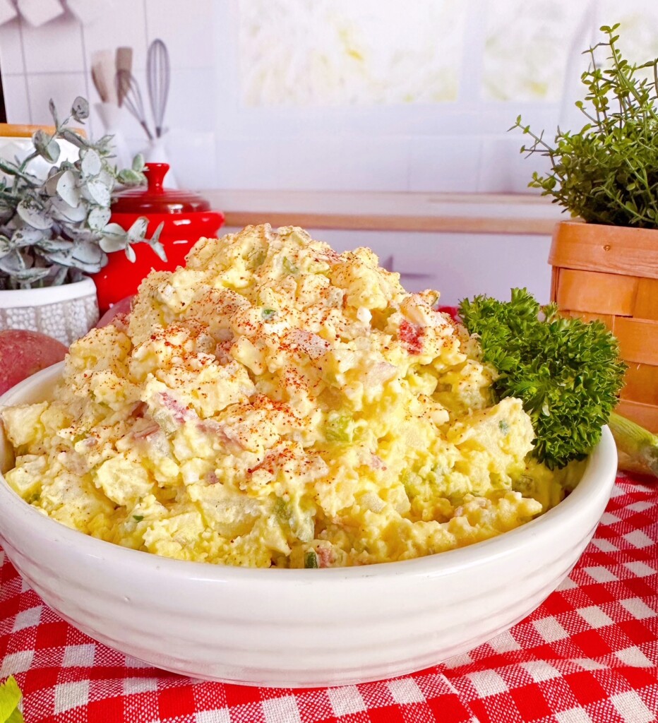 Classic Potato Salad on a checkered red cloth with parsley garnish.