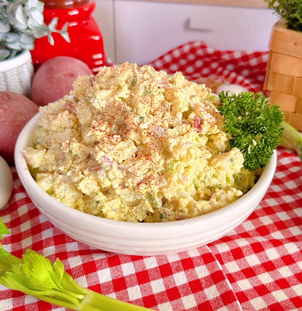 Classic Red Potato Salad in a serving dish on a red and white checkered cloth.