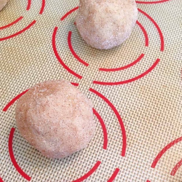 placing cookie balls on baking mat lined with silicone baking mat.