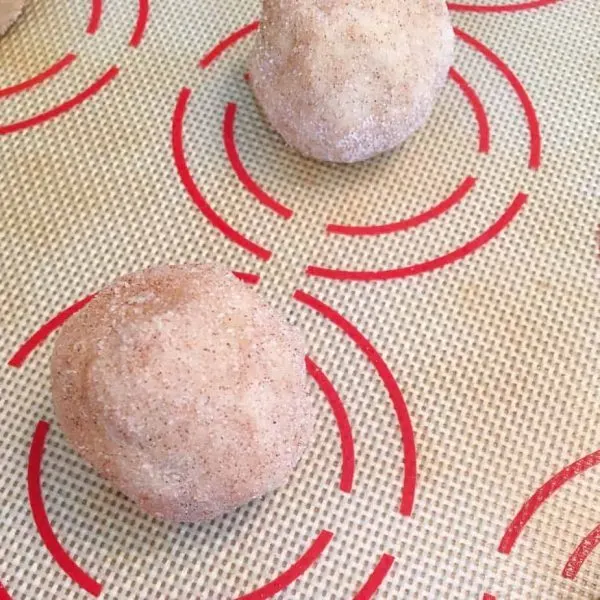 placing cookie balls on baking mat lined with silicone baking mat.