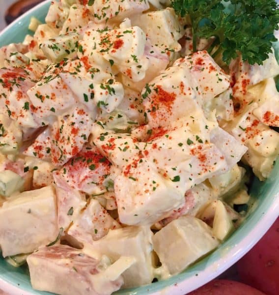 Classic Red Potato Salad in a bowl with paprika and parsley garnish.