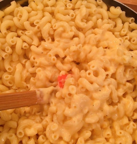 Mixing pasta into cheese sauce in the skillet