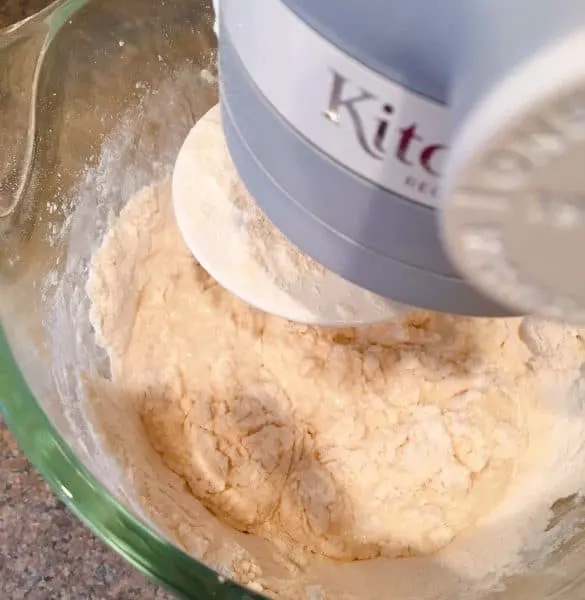 wet and dry ingredients beginning to combine in mixer with dough hook