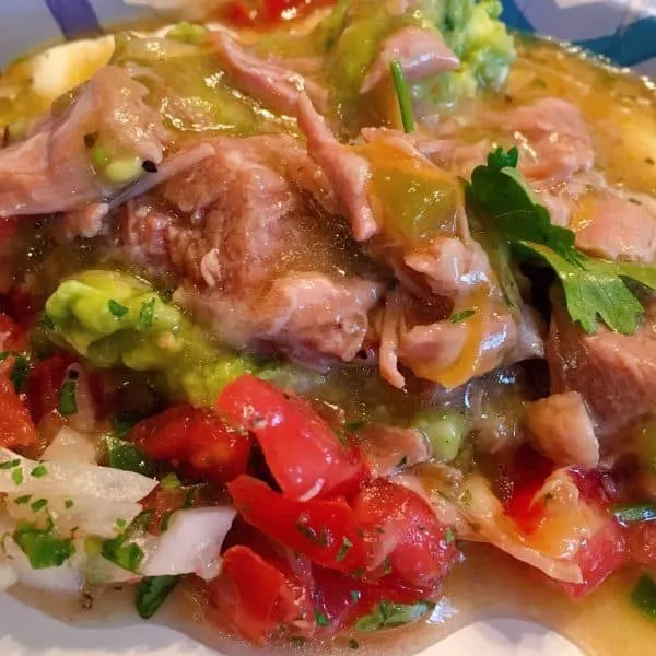 Spoonful of Pork Chile Verde with pico, guacamole, sour cream, and cheese
