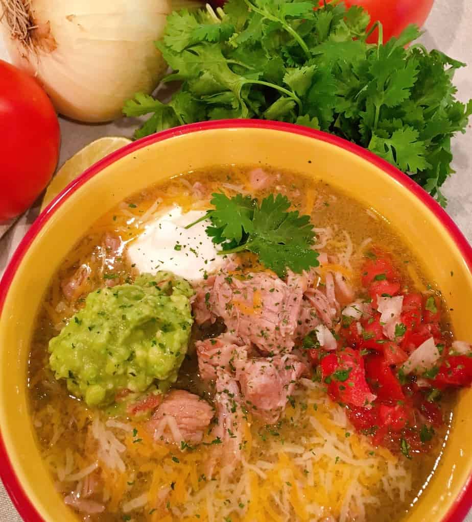 Instant Pot Chili Verde in a bowl with pico, guacamole, sour cream, and cheese