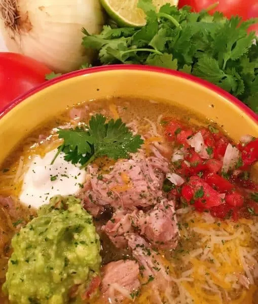 Bowl full of Easy Instant Pot Chili Verde with toppings
