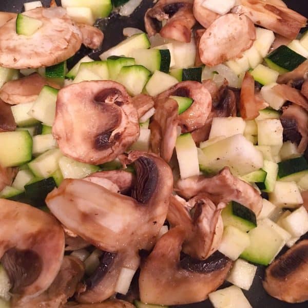 Mushrooms, zucchini, and onions in a hot skillet sauteed in skillet with butter.